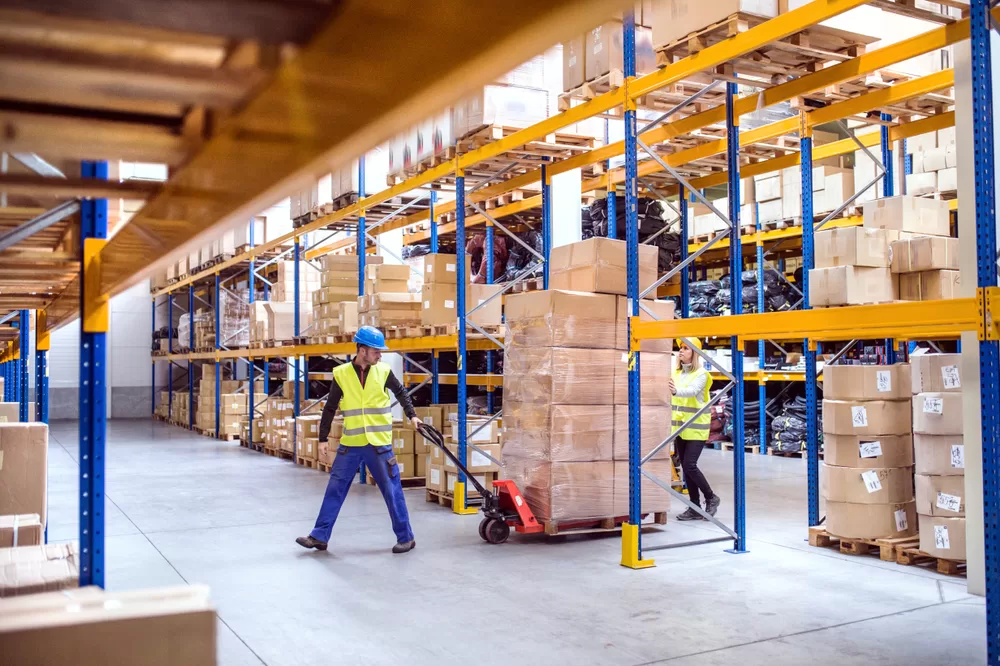 How can warehouse logistics reduce excess inventory in manufacturing?